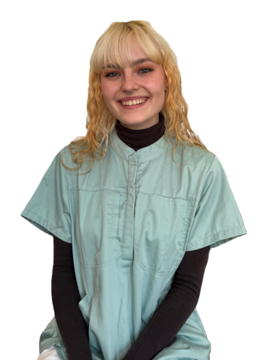 Junge Frau mit blonden Locken, trägt ein mintgrünes Oberteil und lächelt freundlich.